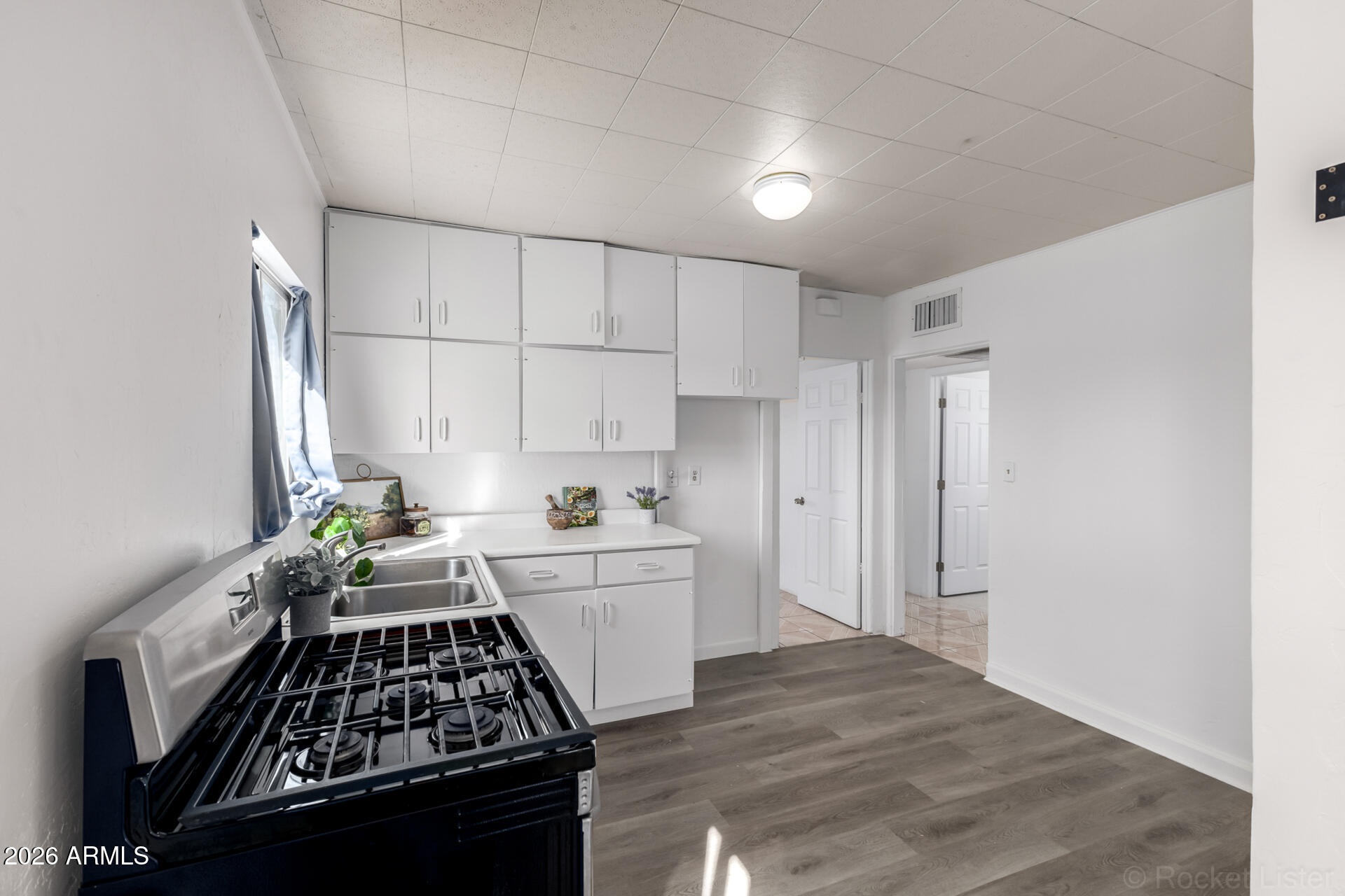 3326 West Culver Street Phoenix, AZ 85009 - Photo 8 of 18 a kitchen with white cabinets and a stove top oven
