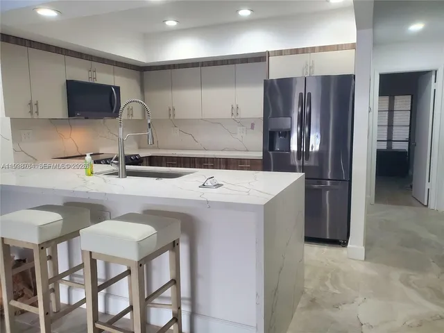 a kitchen with stainless steel appliances a sink and a refrigerator