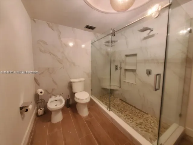 a bathroom with a toilet shower and a sink