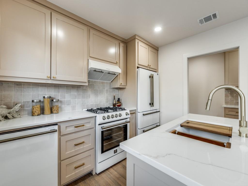 6611 Blessing Drive Dallas, TX 75214 - Photo 16 of 25 a kitchen with granite countertop white cabinets and white appliances