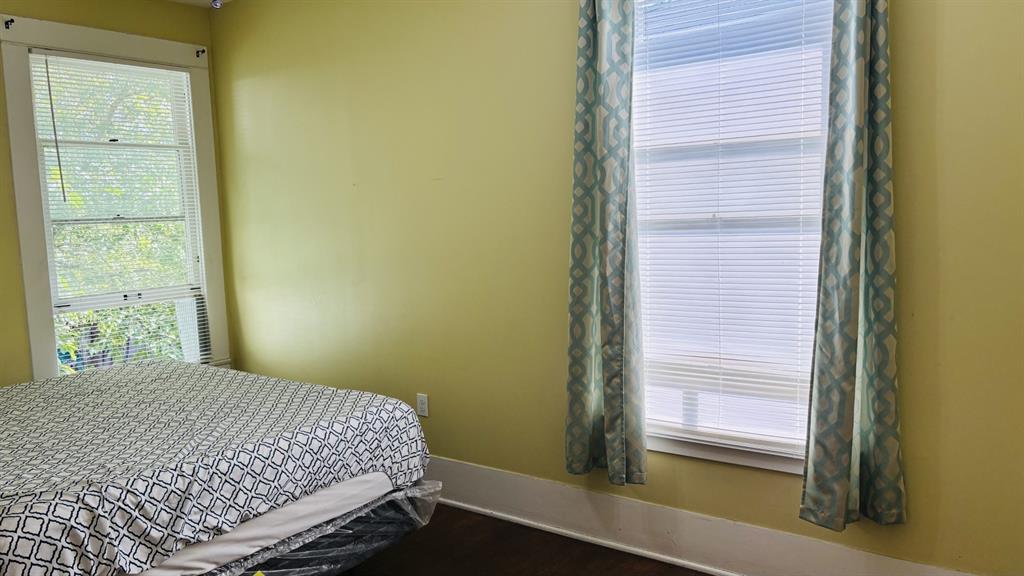 4616 Eastside Avenue, Unit A Dallas, TX 75226 - Photo 17 of 18 Bedroom 2 with dark wood finished floors and baseboards