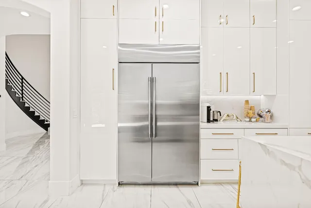 a spacious bedroom with a bed a table and a potted plant on the dresser