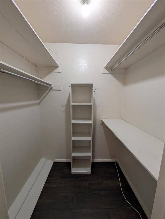 4715 Skillman Street, Unit A Dallas, TX 75206 - Photo 21 of 28 Walk-in closet with dark wood-finish flooring, white built-in shelving, white overhead shelving, and metal clothing rods