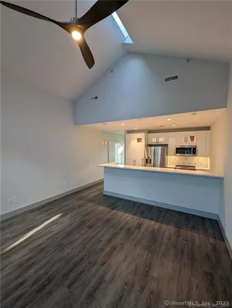 a view of a hallway with wooden floor and a living room