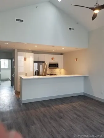an open kitchen with a refrigerator and a sink