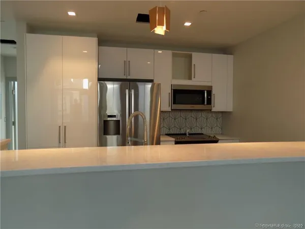a kitchen with stainless steel appliances granite countertop a refrigerator and a stove