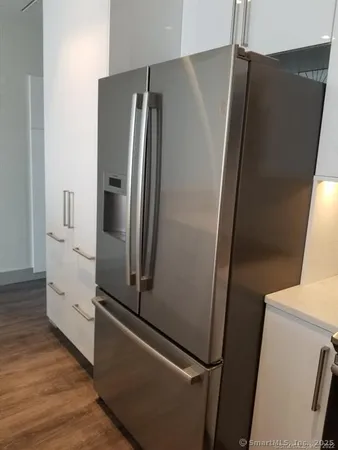 a close view of a sink and dishwasher with wooden floor