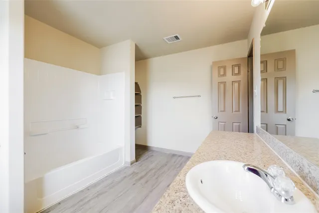 a view of a bedroom with wooden floor