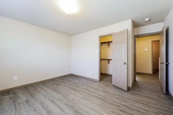 an empty room with wooden floor and closet