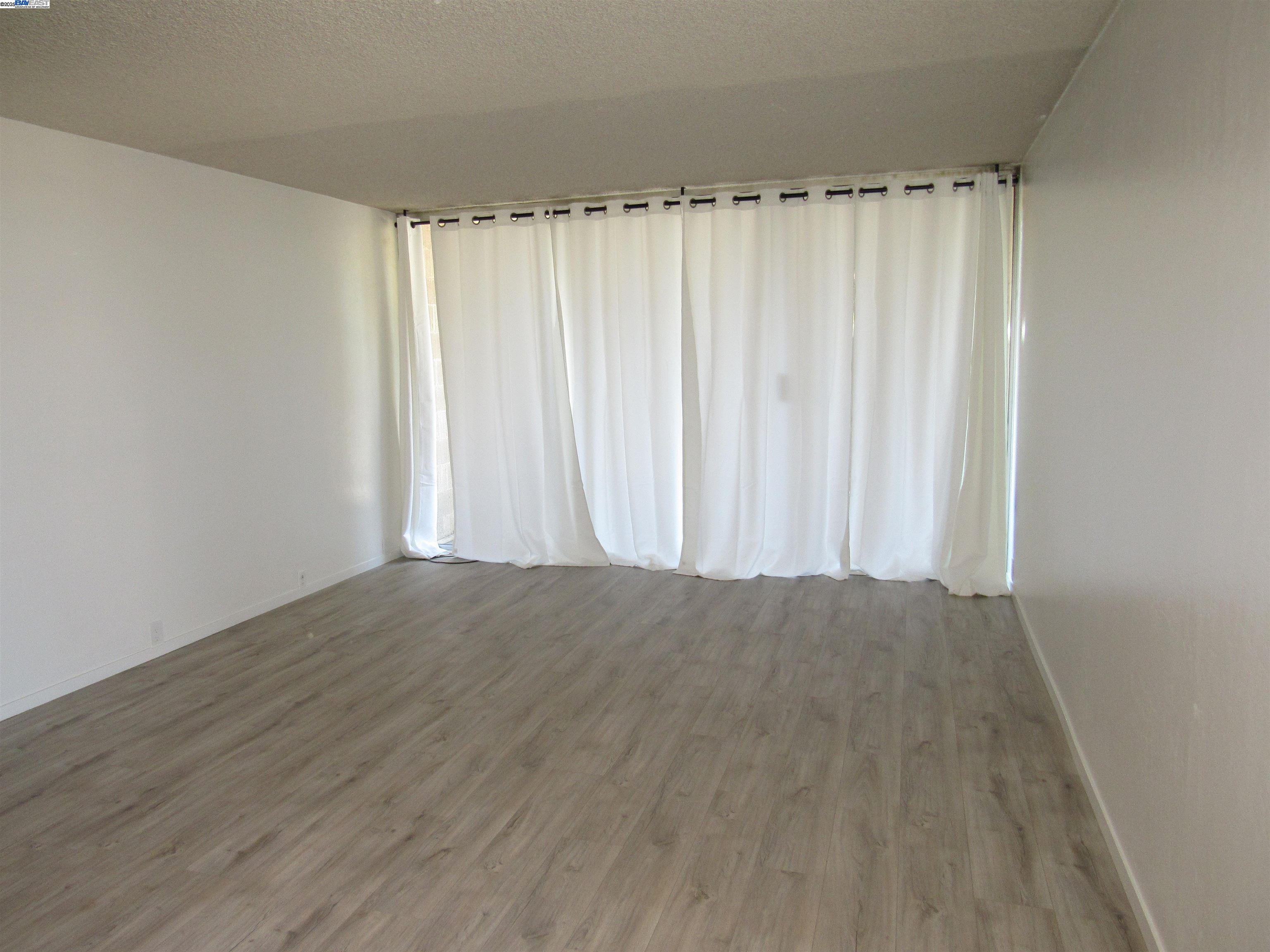 3909 Stevenson Boulevard, Unit 402 Fremont, CA 94538 - Photo 13 of 32 a view of a curtain with wooden floor