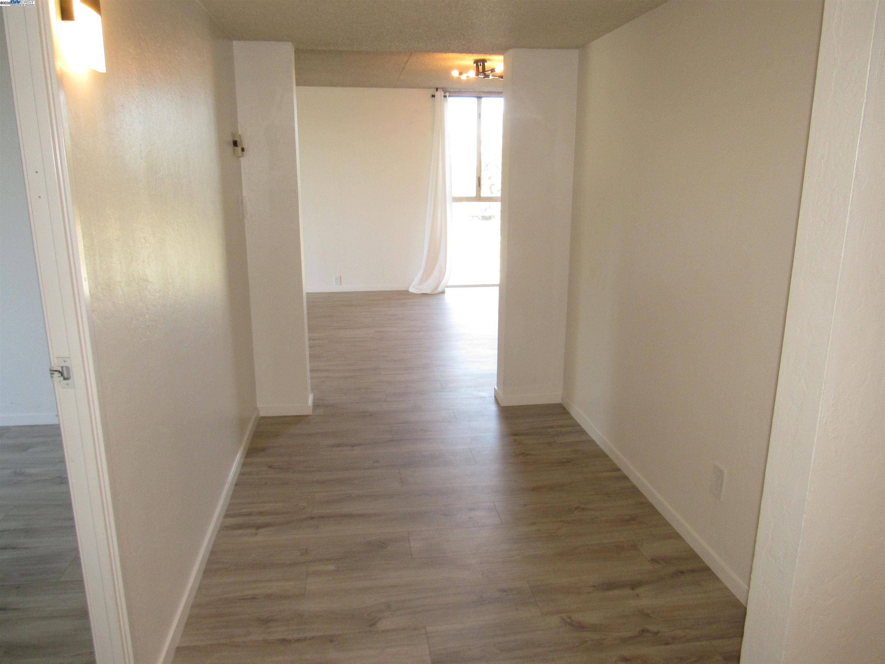 3909 Stevenson Boulevard, Unit 402 Fremont, CA 94538 - Photo 3 of 32 a view of a hallway with wooden floor