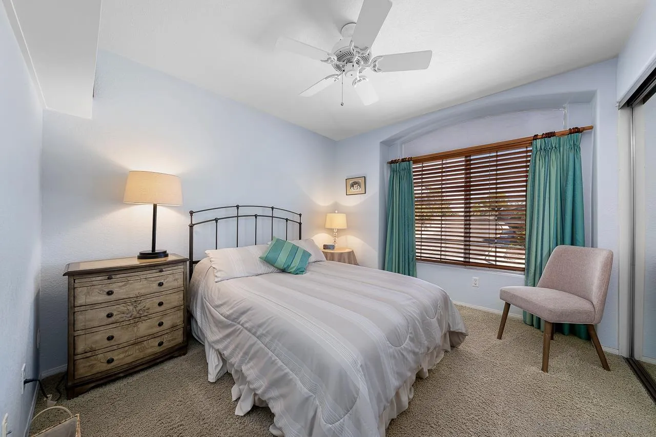 5114 Bella Collina Street Oceanside, CA 92056 - Photo 34 of 74 a bedroom with a bed a chair and with a large window