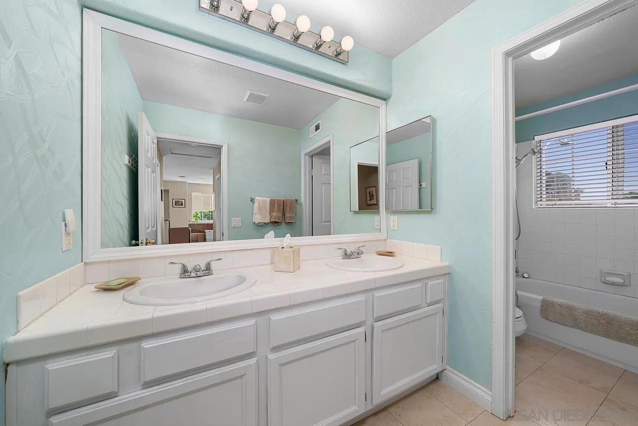 5114 Bella Collina Street Oceanside, CA 92056 - Photo 36 of 74 a bathroom with a double vanity sink mirror and bathtub
