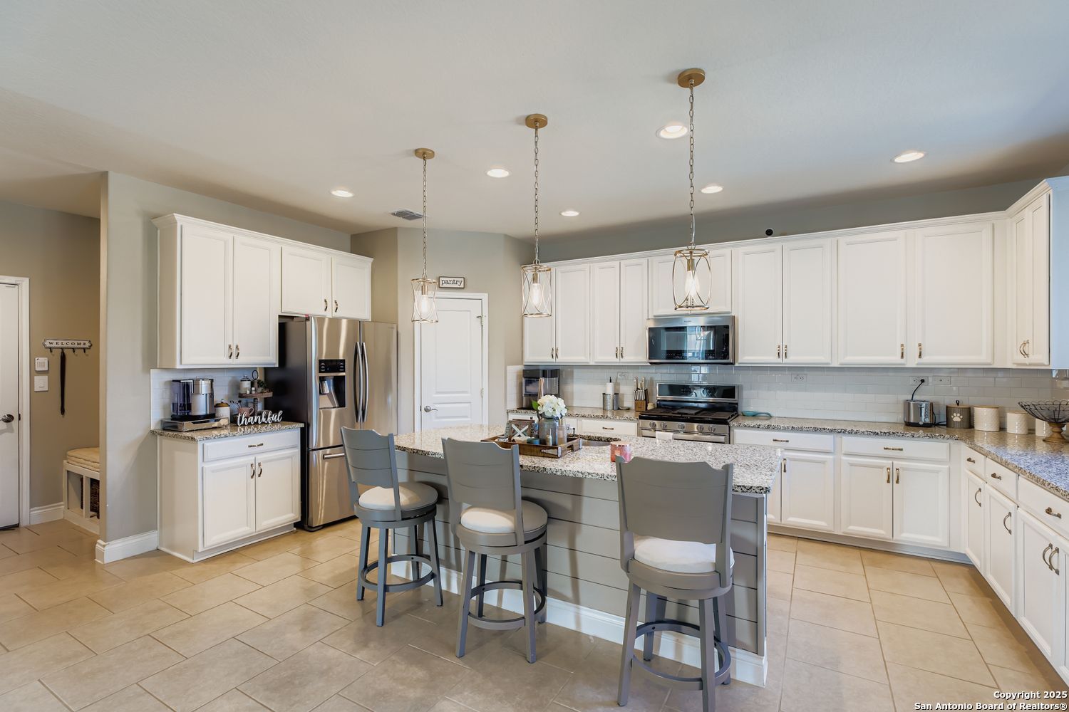 10639 Hibiscus Cove Helotes, TX 78023 - Photo 14 of 34 a kitchen with refrigerator a stove and chairs