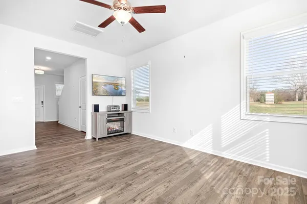 a view of a kitchen with wooden floor and a ceiling fan