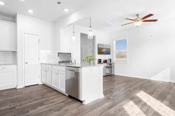 a kitchen with kitchen island white cabinets and stainless steel appliances