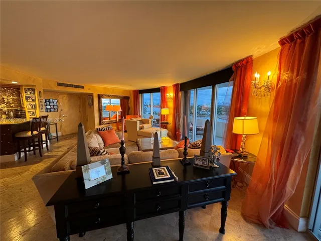 a living room with furniture a flat screen tv and a refrigerator