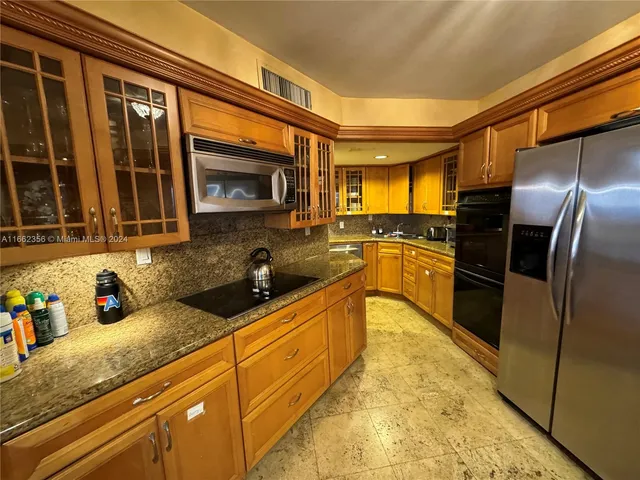 a kitchen with stainless steel appliances granite countertop a refrigerator a sink dishwasher stove and oven