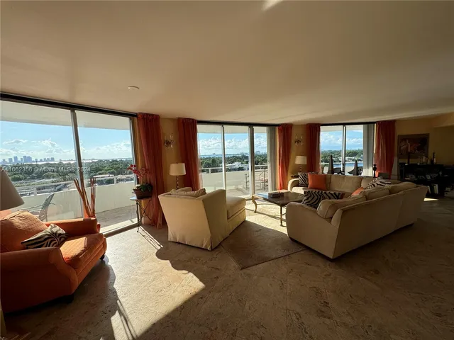 a living room with furniture and floor to ceiling windows