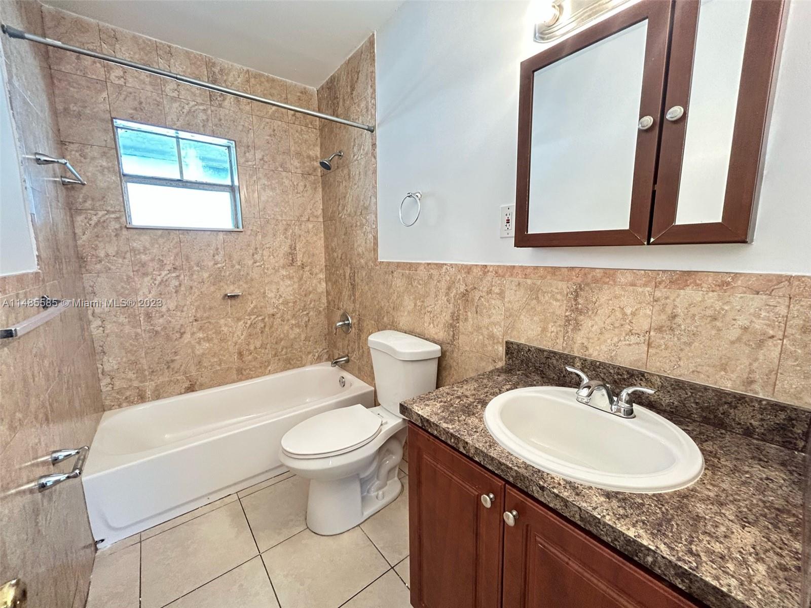 990 Phippen Waiters Road, Unit 1 Dania Beach, FL 33004 - Photo 4 of 8 a bathroom with a sink and a mirror