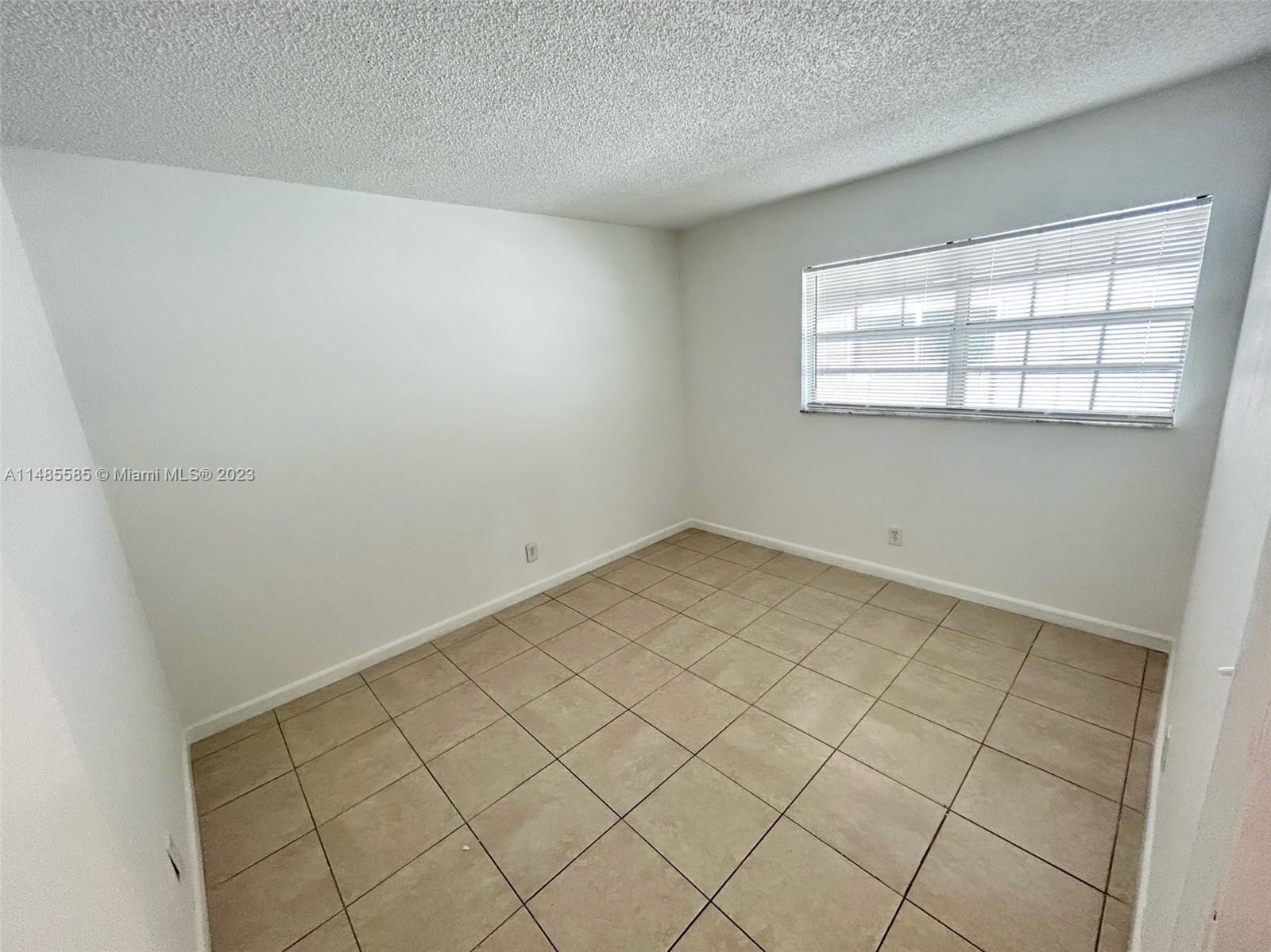 990 Phippen Waiters Road, Unit 1 Dania Beach, FL 33004 - Photo 5 of 8 an empty room with windows
