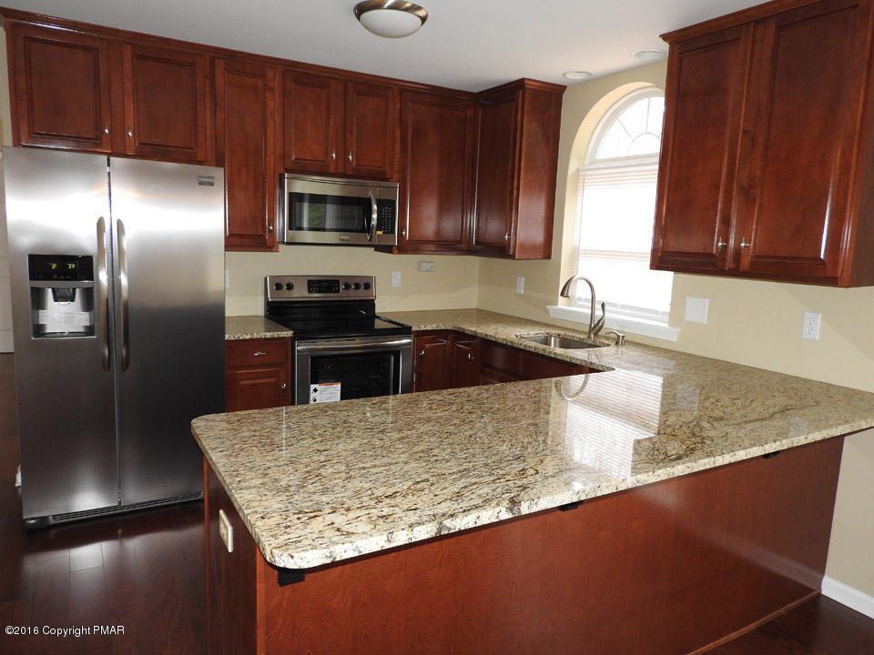 137 Lidio Road Blakeslee, PA 18610 - Photo 3 of 28 a kitchen with granite countertop a sink a counter top space cabinets and stainless steel appliances