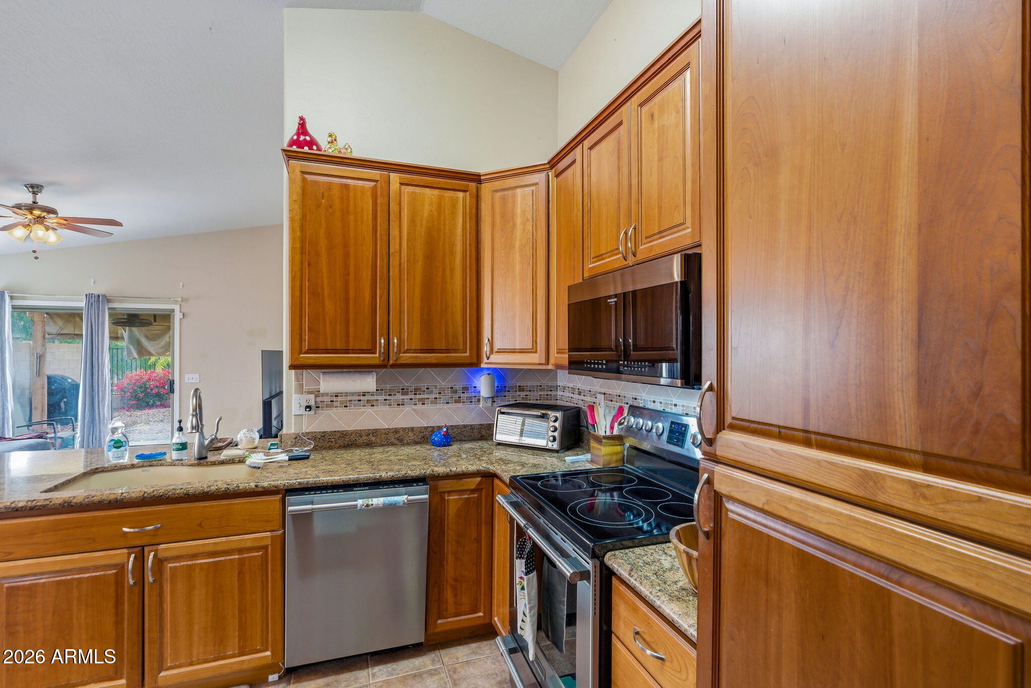 15843 West Washington Street Goodyear, AZ 85338 - Photo 12 of 39 a kitchen with granite countertop a sink and a stove top oven