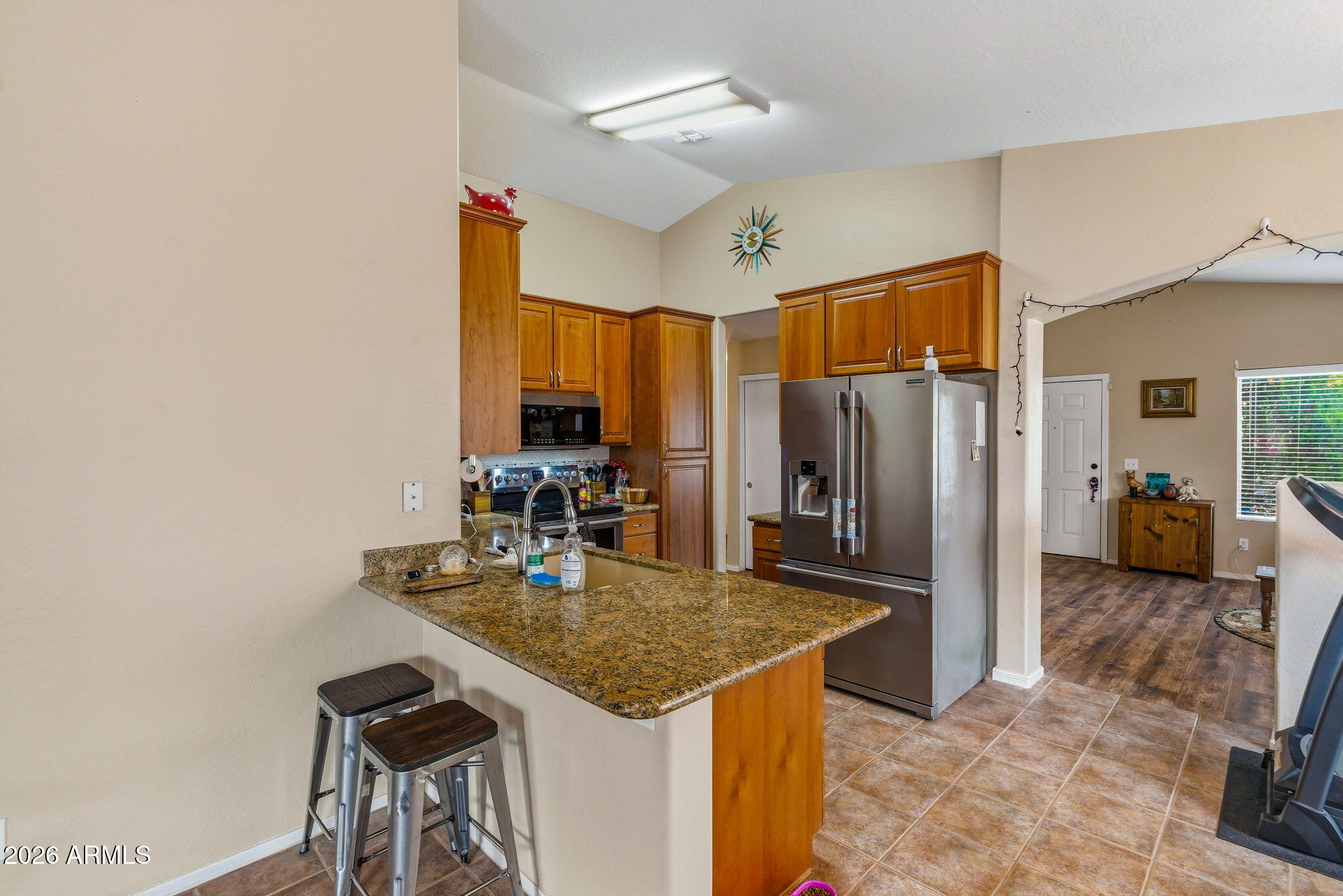 15843 West Washington Street Goodyear, AZ 85338 - Photo 13 of 39 a kitchen with stainless steel appliances granite countertop a sink and a refrigerator