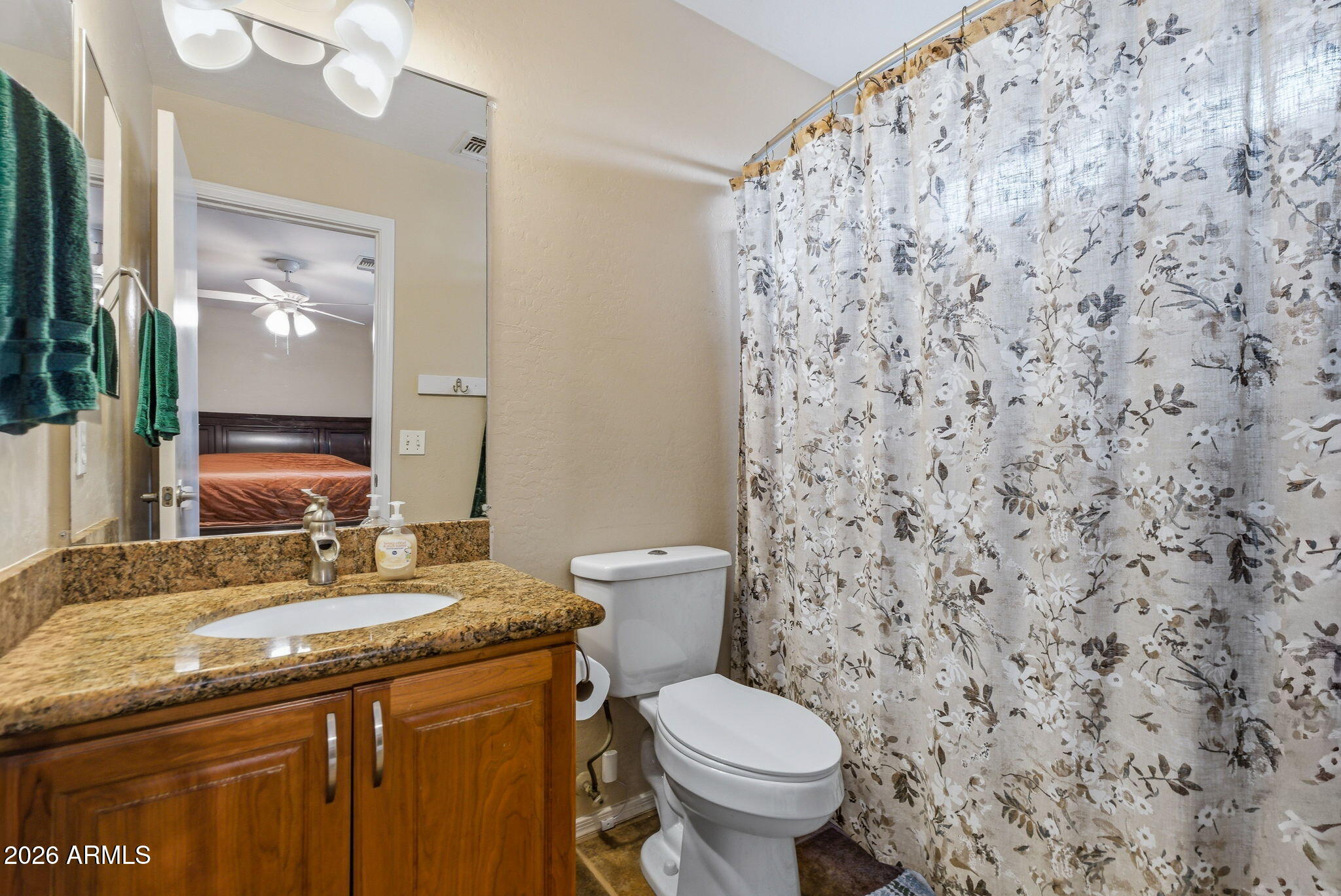 15843 West Washington Street Goodyear, AZ 85338 - Photo 32 of 39 a bathroom with a granite countertop toilet sink and mirror