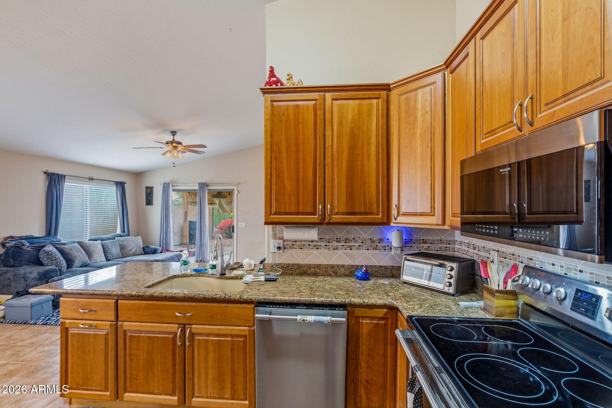 15843 West Washington Street Goodyear, AZ 85338 - Photo 9 of 39 a kitchen with stainless steel appliances a sink a stove and a microwave