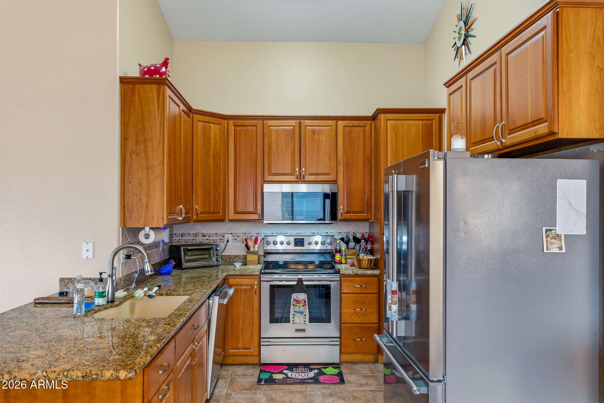 15843 West Washington Street Goodyear, AZ 85338 - Photo 10 of 39 a kitchen with stainless steel appliances granite countertop a stove a sink dishwasher and a refrigerator