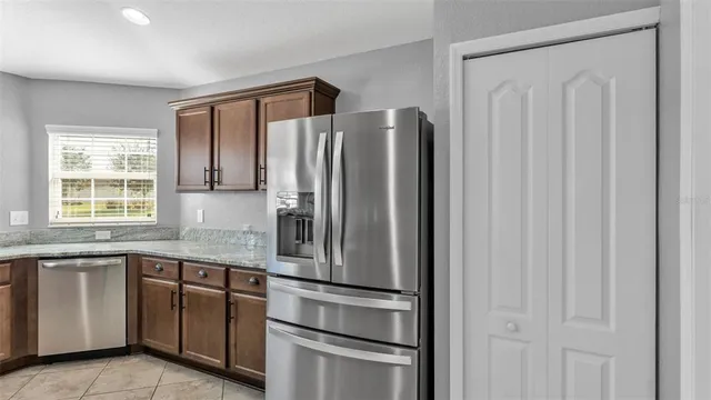 a kitchen with stainless steel appliances granite countertop a refrigerator and a sink