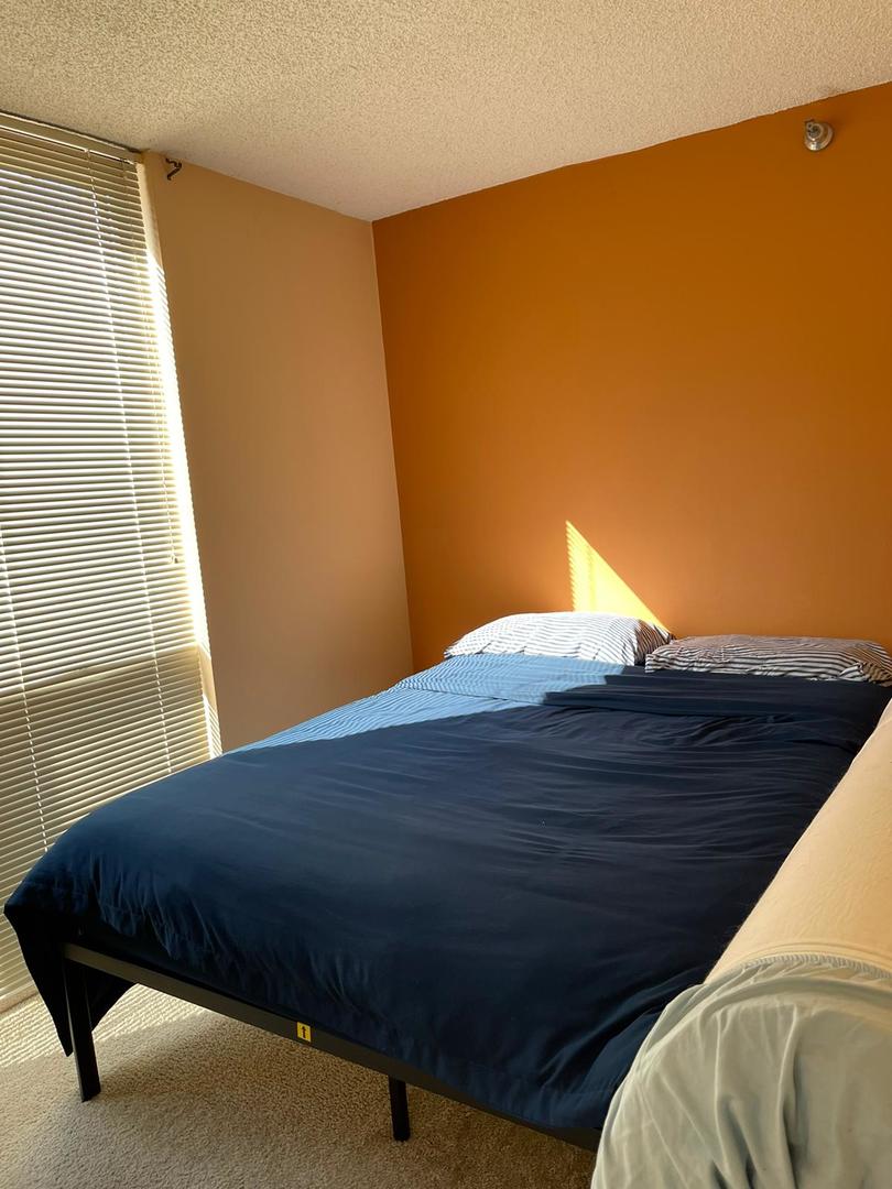 200 North Dearborn Street, Unit 1901 Chicago, IL 60601 - Photo 13 of 24 a bed sitting in a bedroom next to a window