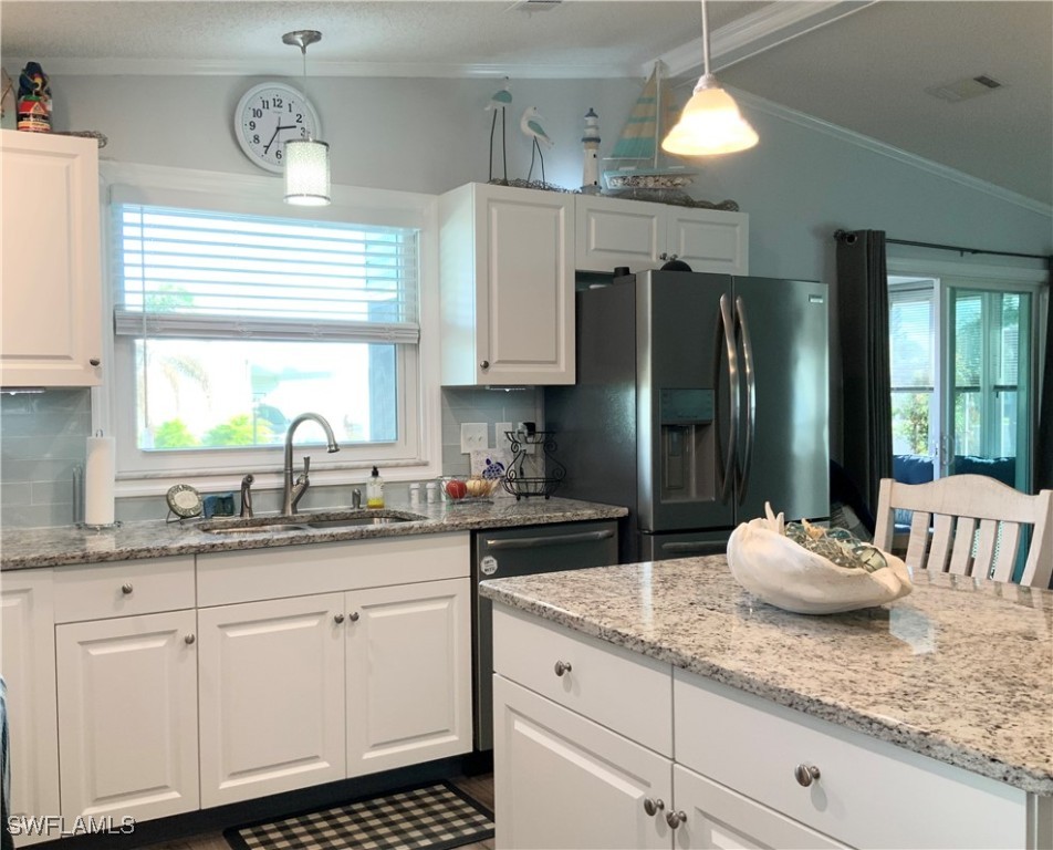 15550 Burnt Store Road, Unit 86 Punta Gorda, FL 33955 - Photo 10 of 36 a kitchen with kitchen island granite countertop a sink stainless steel appliances and cabinets