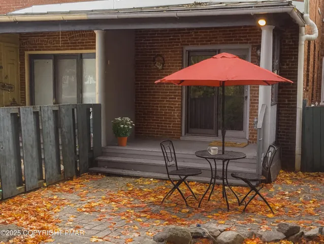 a backyard of a house with barbeque oven table and chairs