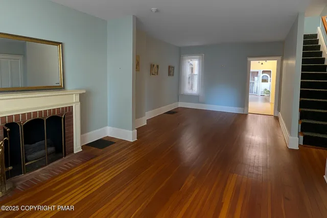 a view of a livingroom with wooden floor and a fireplace