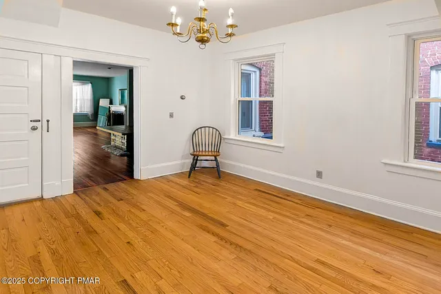 a bedroom with a bed chandelier and a window