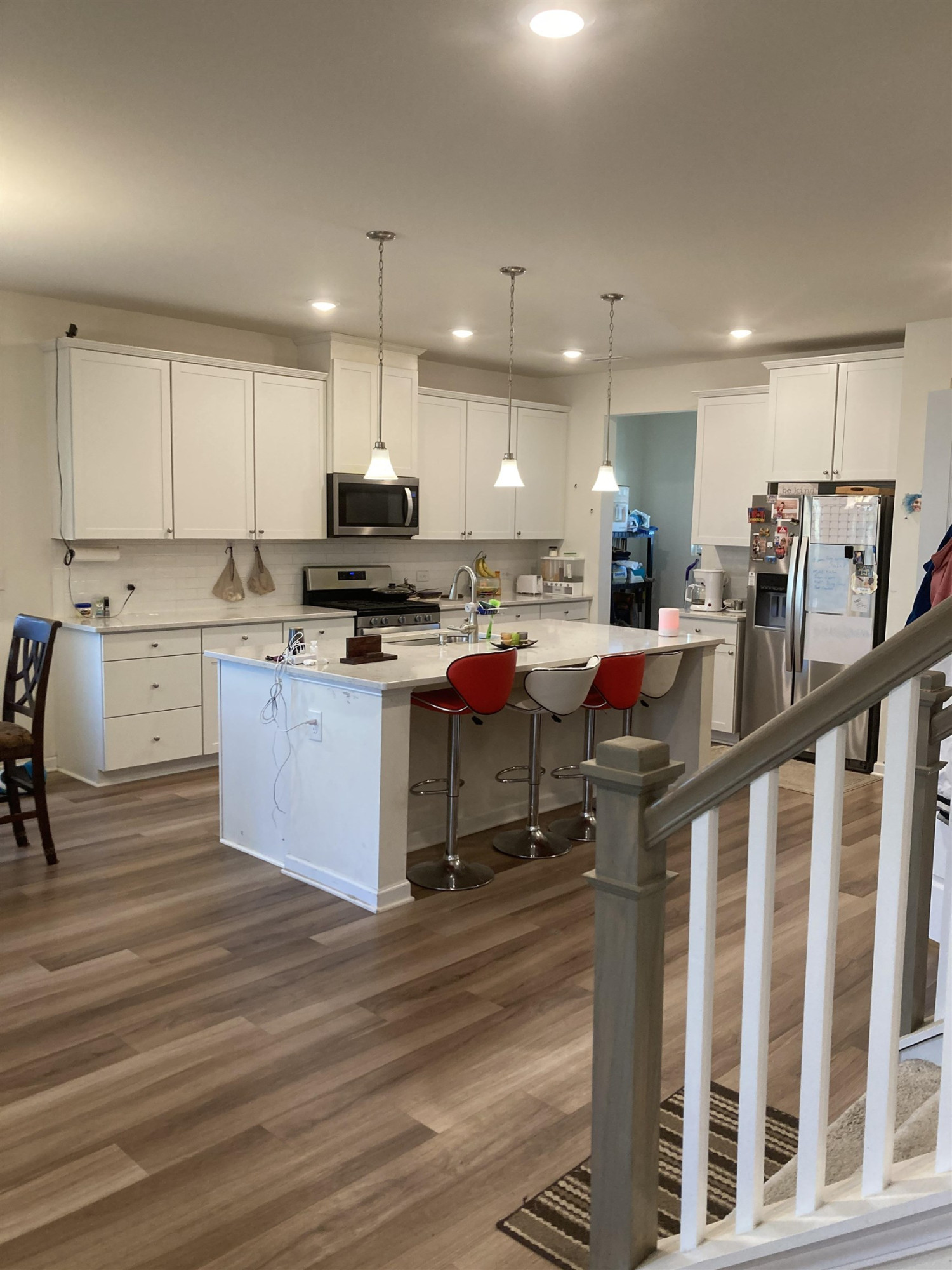 3514 Barn Road Apex, NC 27502 - Photo 44 of 53 a kitchen with stainless steel appliances kitchen island granite countertop a stove a sink a refrigerator and white cabinets with wooden floor