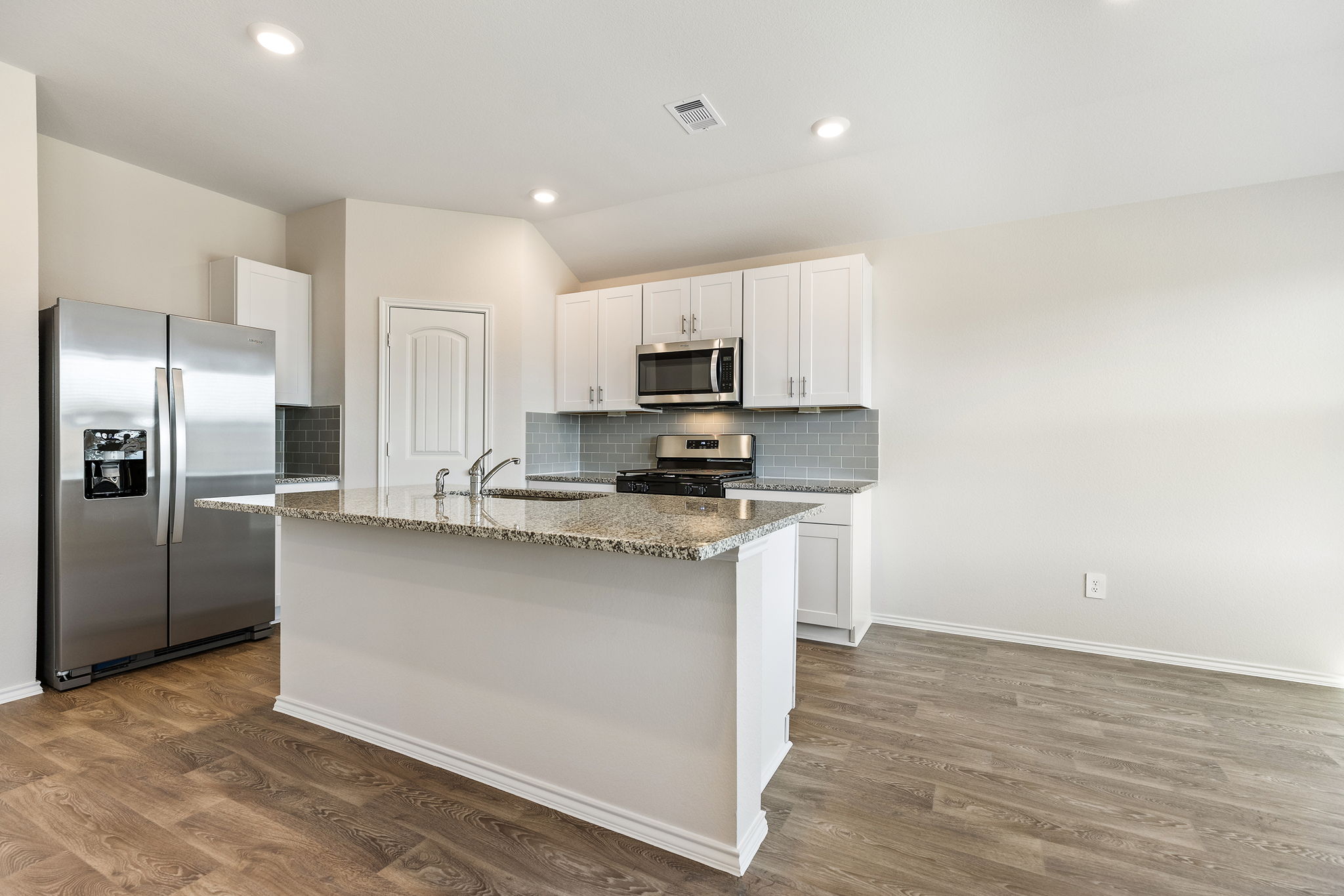 1702 Miller Terrace Lockhart, TX 78644 - Photo 6 of 21 a kitchen with stainless steel appliances granite countertop a stove a sink and a refrigerator