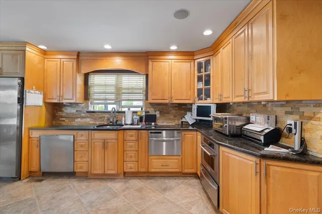 a kitchen with stainless steel appliances granite countertop a refrigerator and a stove top oven