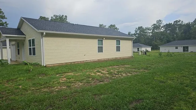 a view of a backyard with plants and large tree