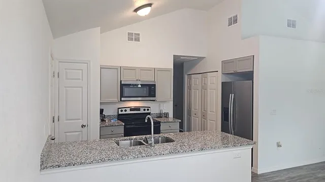 a kitchen with stainless steel appliances granite countertop a sink stove and refrigerator
