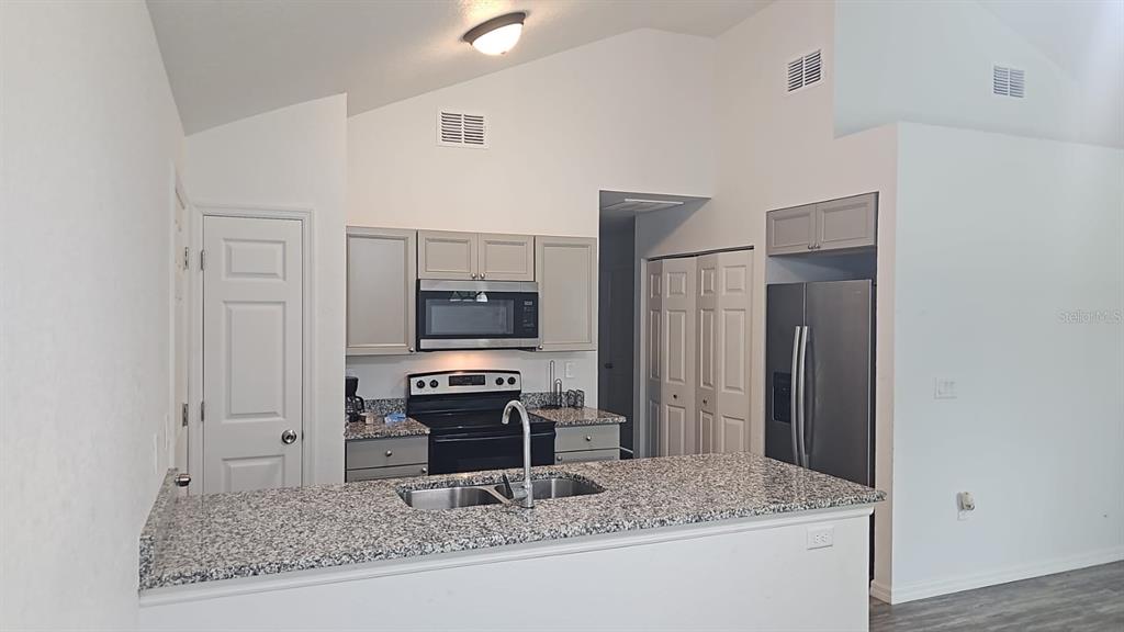 15028 Southwest 24th Place Ocala, FL 34481 - Photo 3 of 25 a kitchen with stainless steel appliances granite countertop a sink stove and refrigerator