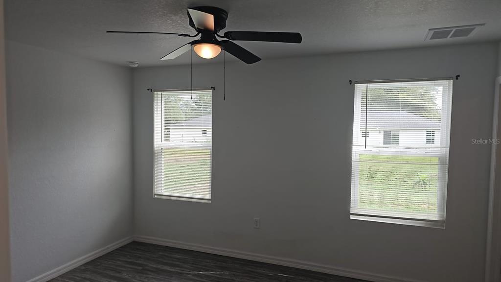 15028 Southwest 24th Place Ocala, FL 34481 - Photo 8 of 25 a view of an empty room with wooden floor and a window