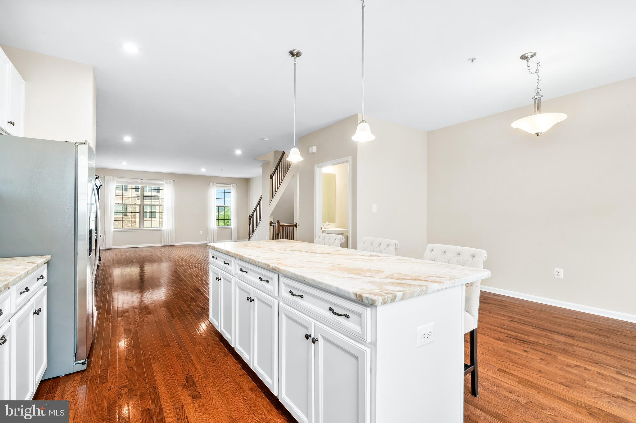 8479 Randell Ridge Road Frederick, MD 21704 - Photo 12 of 50 a large kitchen with kitchen island a stove a sink a refrigerator and a view of living room with wooden floor