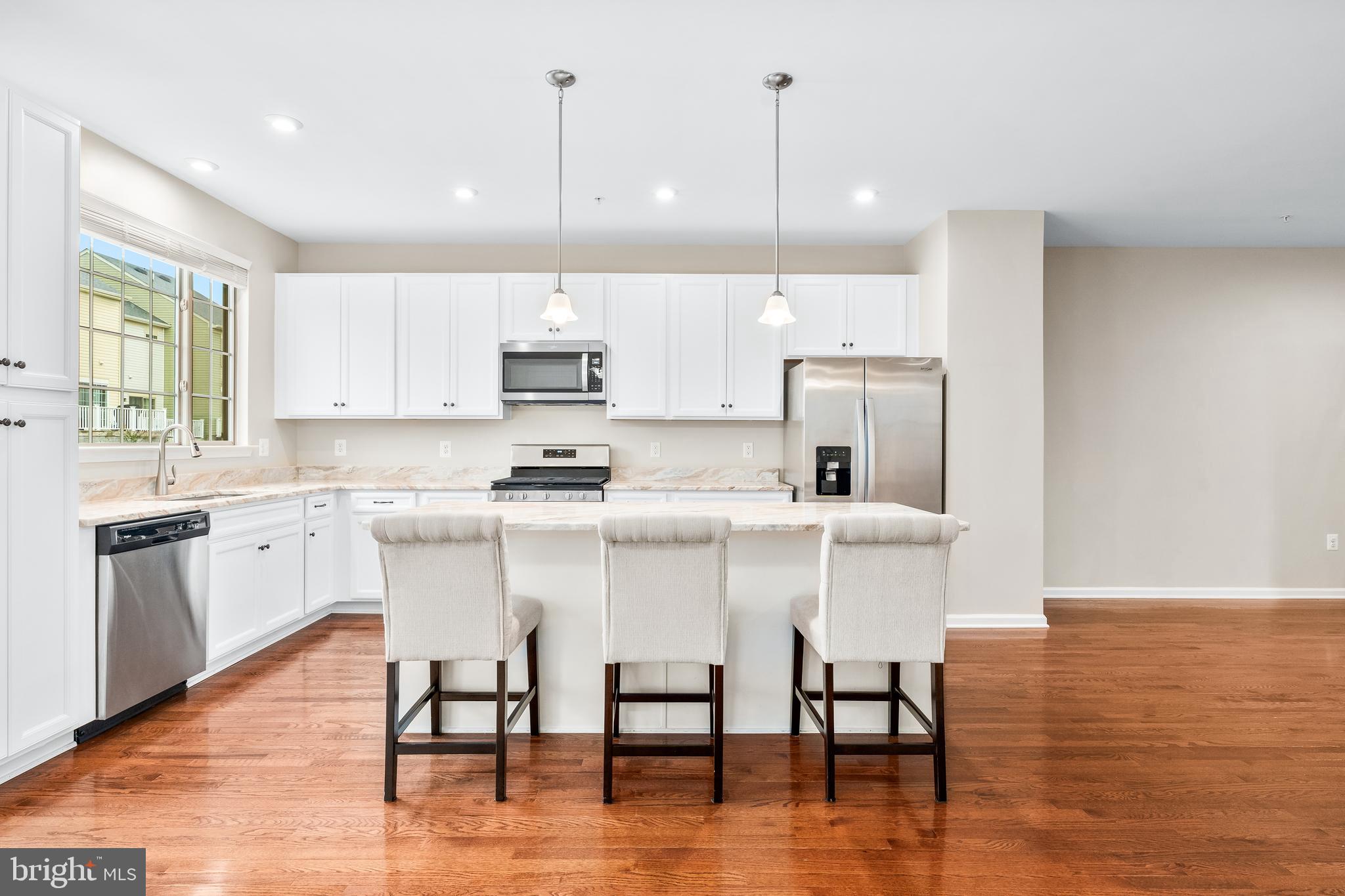 8479 Randell Ridge Road Frederick, MD 21704 - Photo 15 of 50 a kitchen with stainless steel appliances granite countertop a table chairs stove microwave and cabinets