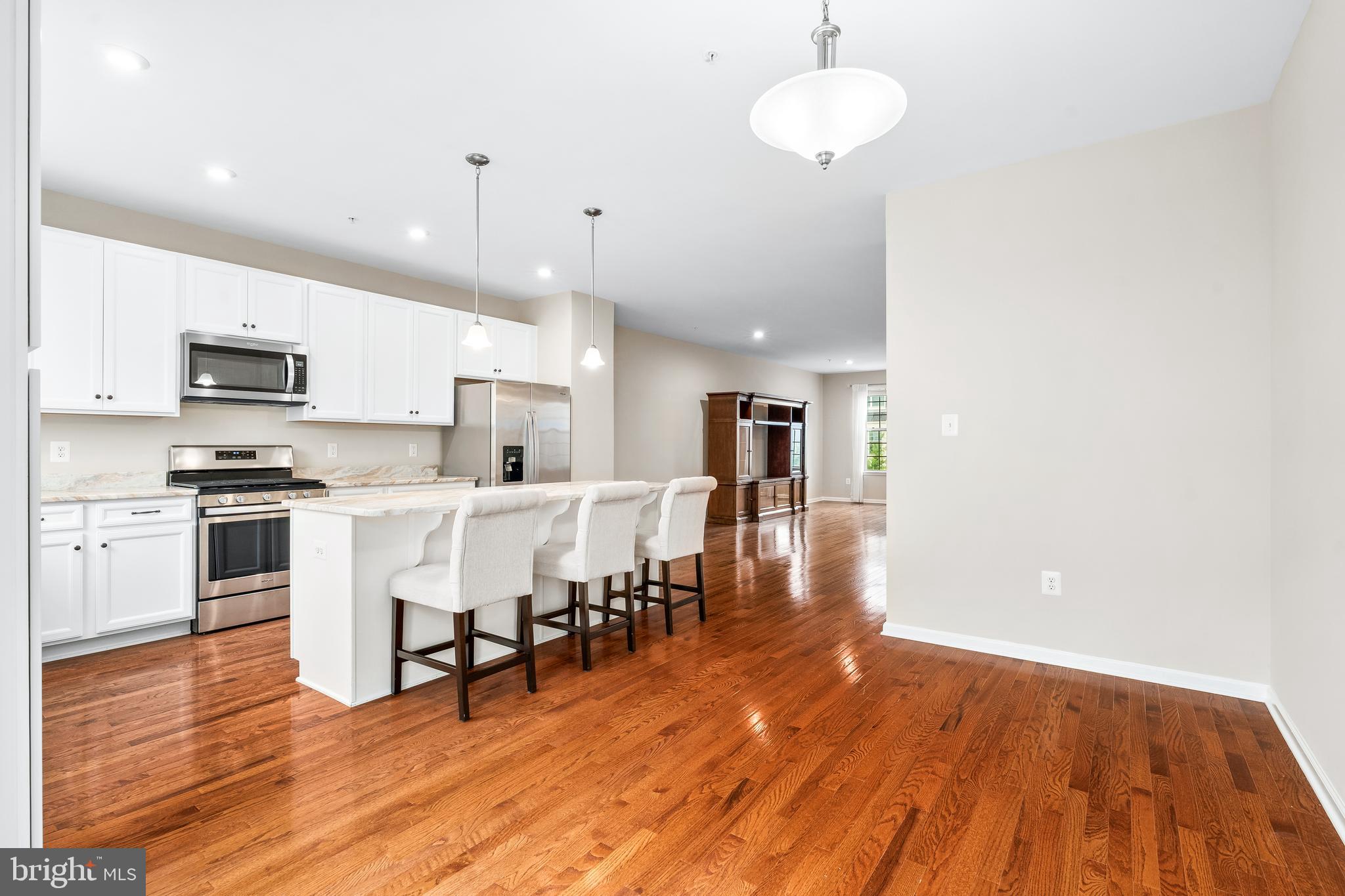 8479 Randell Ridge Road Frederick, MD 21704 - Photo 8 of 50 a kitchen with stainless steel appliances a dining table chairs stove and microwave