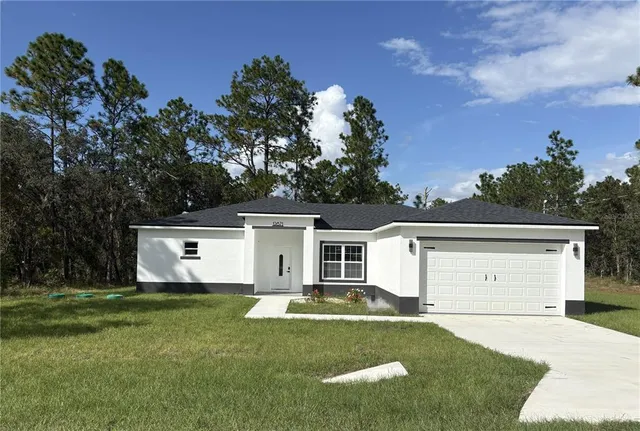 a front view of a house with a garden and yard