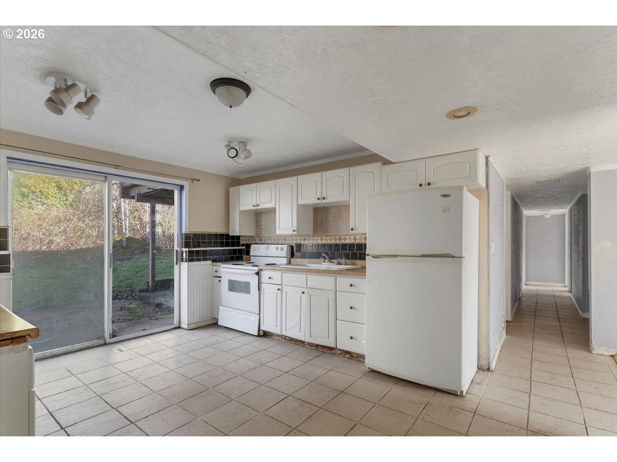 1645 Southwest 27th Street Gresham, OR 97080 - Photo 30 of 48 a kitchen with a refrigerator and white cabinets