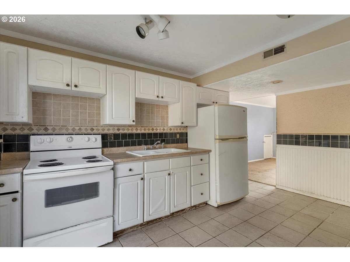 1645 Southwest 27th Street Gresham, OR 97080 - Photo 32 of 48 a kitchen with white cabinets and white appliances